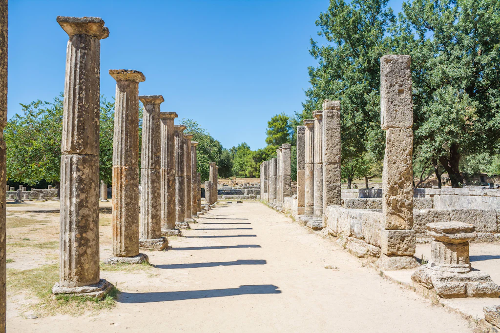 A row of stone columns lining a path in Ancient Olympia, Greece.