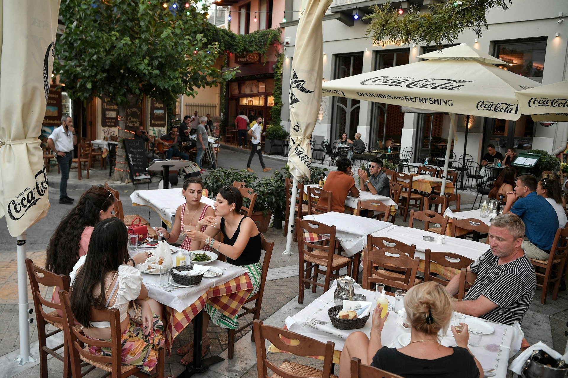 Tourists and Greek clients enjoy a meal at an outdoor restaurant in central Athen