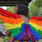 A woman in rainbow colored angel wings participating in the Austin pride festival
