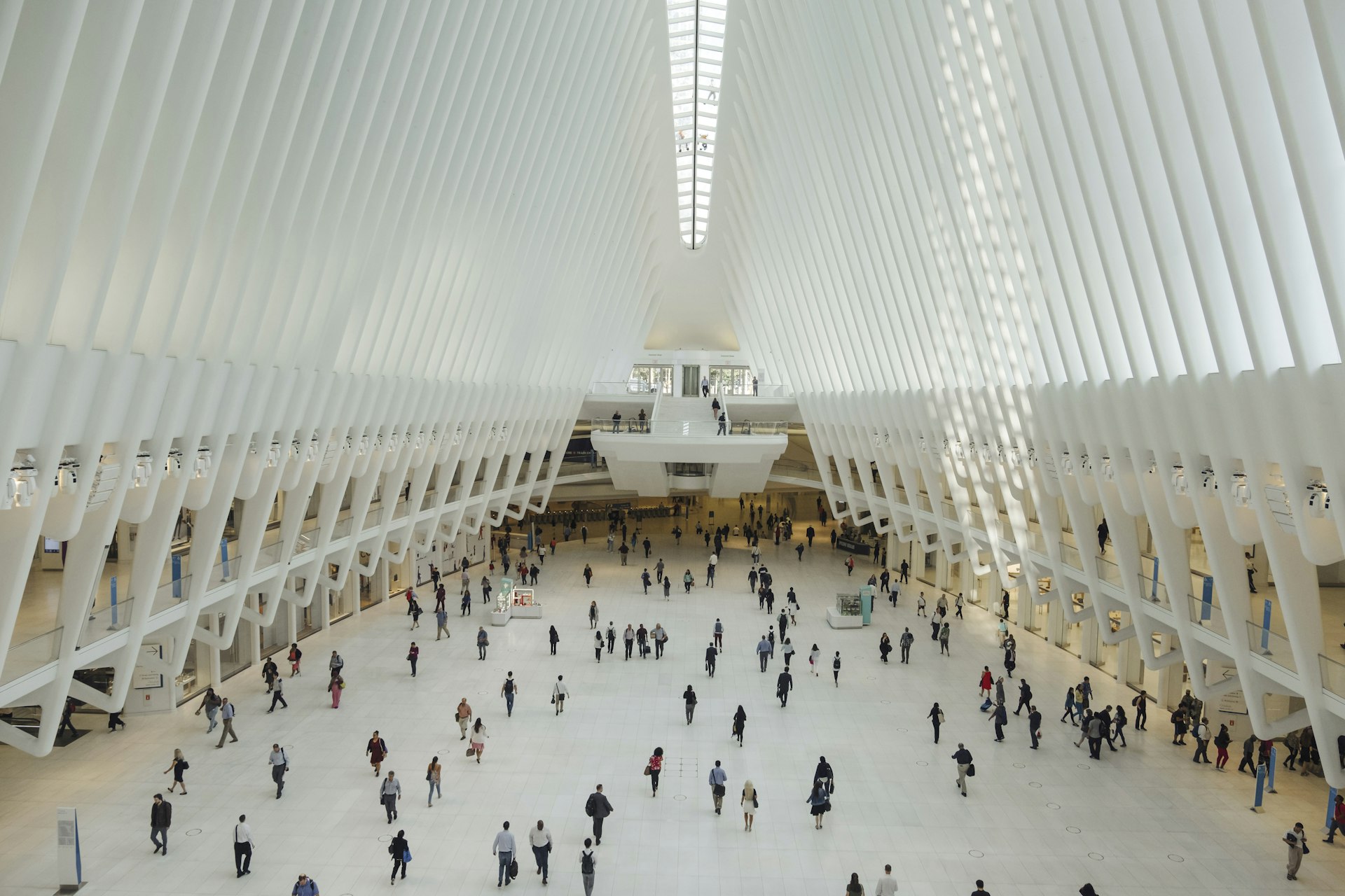 Morning commuters walk around the light-filled central hall (the Oculus) inside the World Trade Center PATH Station.