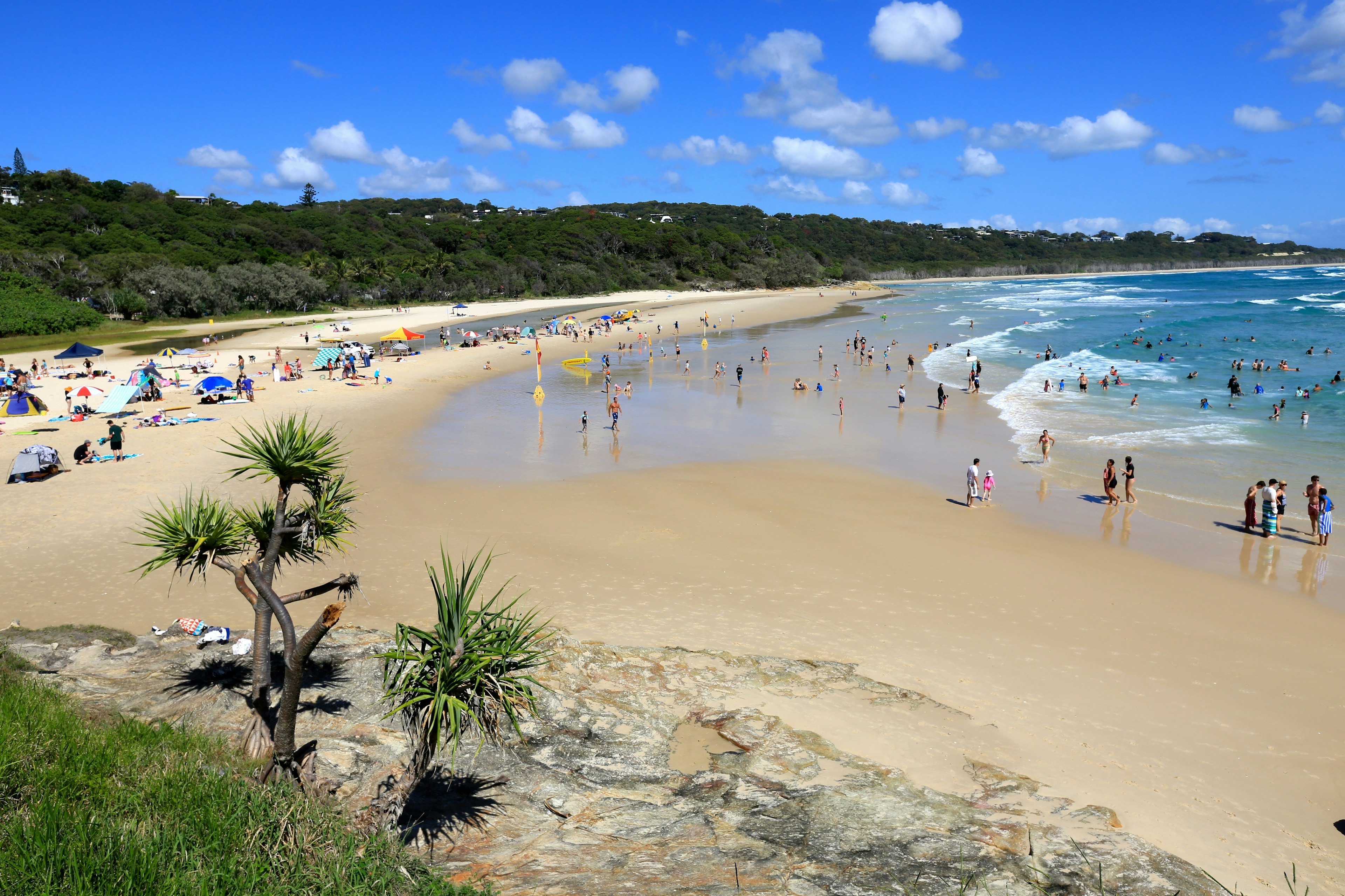 People sunbathing along a stretch of sand at Cylinder Beach, Brisbane