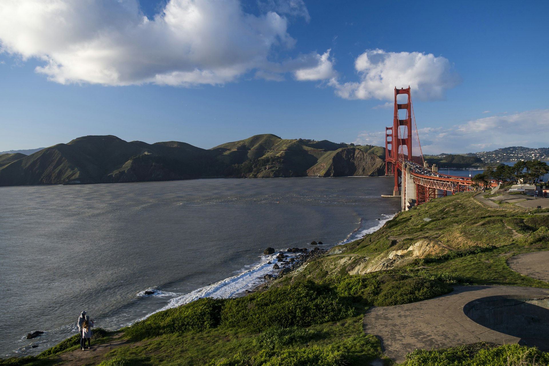 A couple looks out towards the Golden Gate Bridge from Fort Scott at the Presidio in San Francisco, California, U.S.
