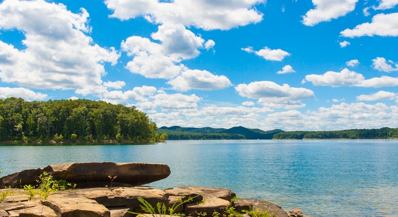 Summer view of local lake Cave Run with beautiful forest on lake hillside shore and dramatic cloudscape sky in Kentucky, USA