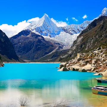 Wooden boats anchored on Paron lake in Cordillera Blanca.