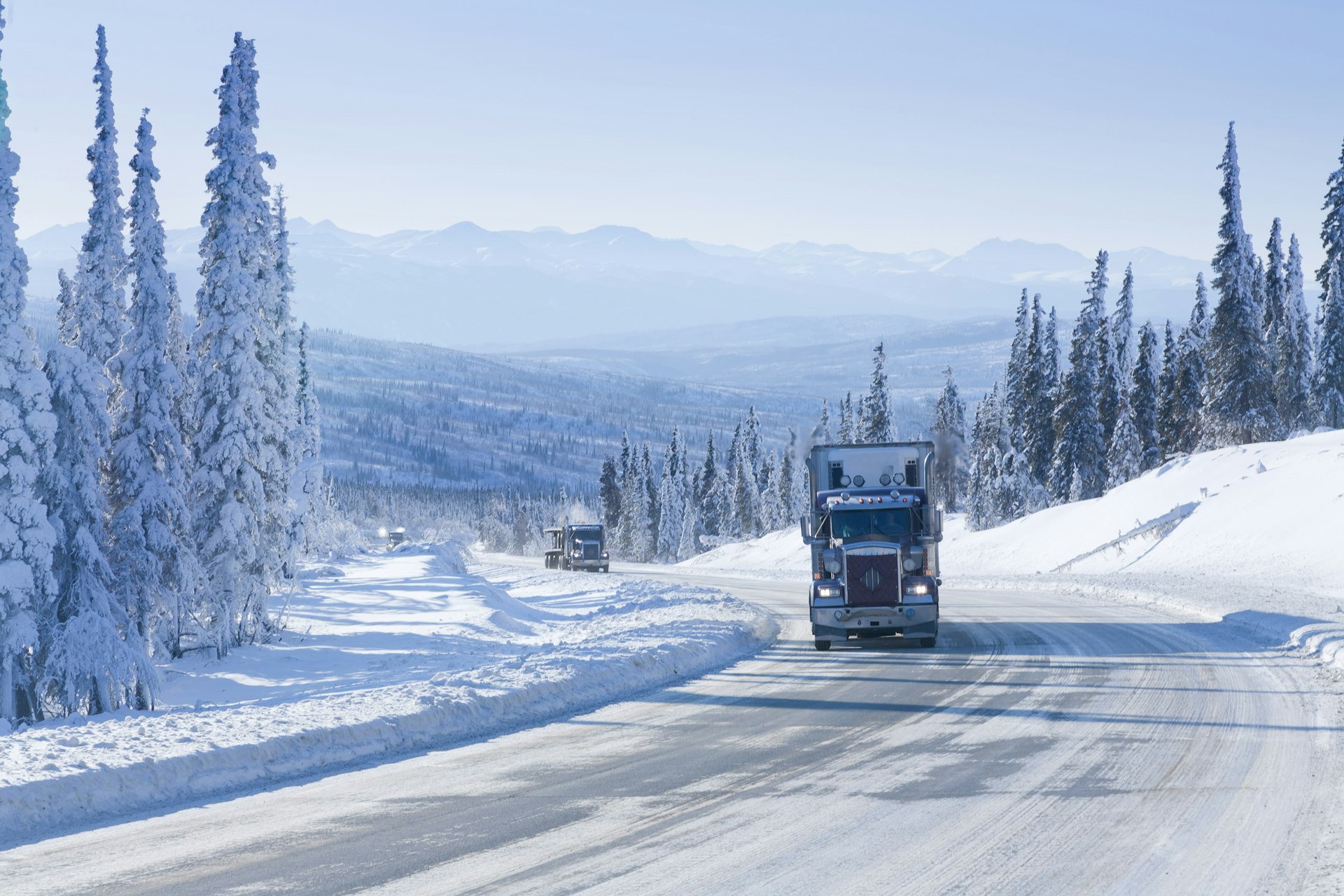 A large truck drives along the ice-covered Dalton Highway in Alaska