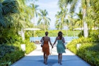 Lesbian couple holding hands at tropical resort