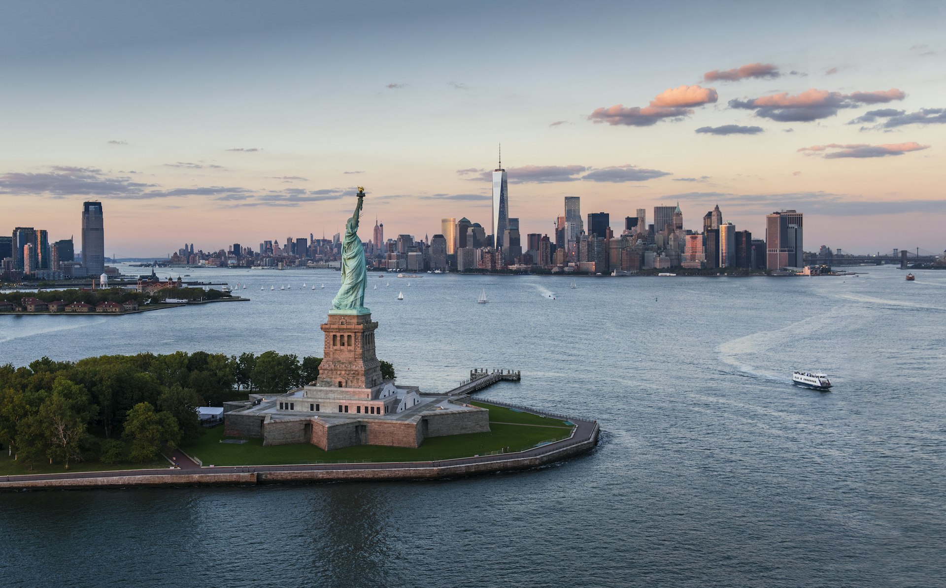 USA, New York State, New York City, Aerial view of city with Statue of Liberty at sunset