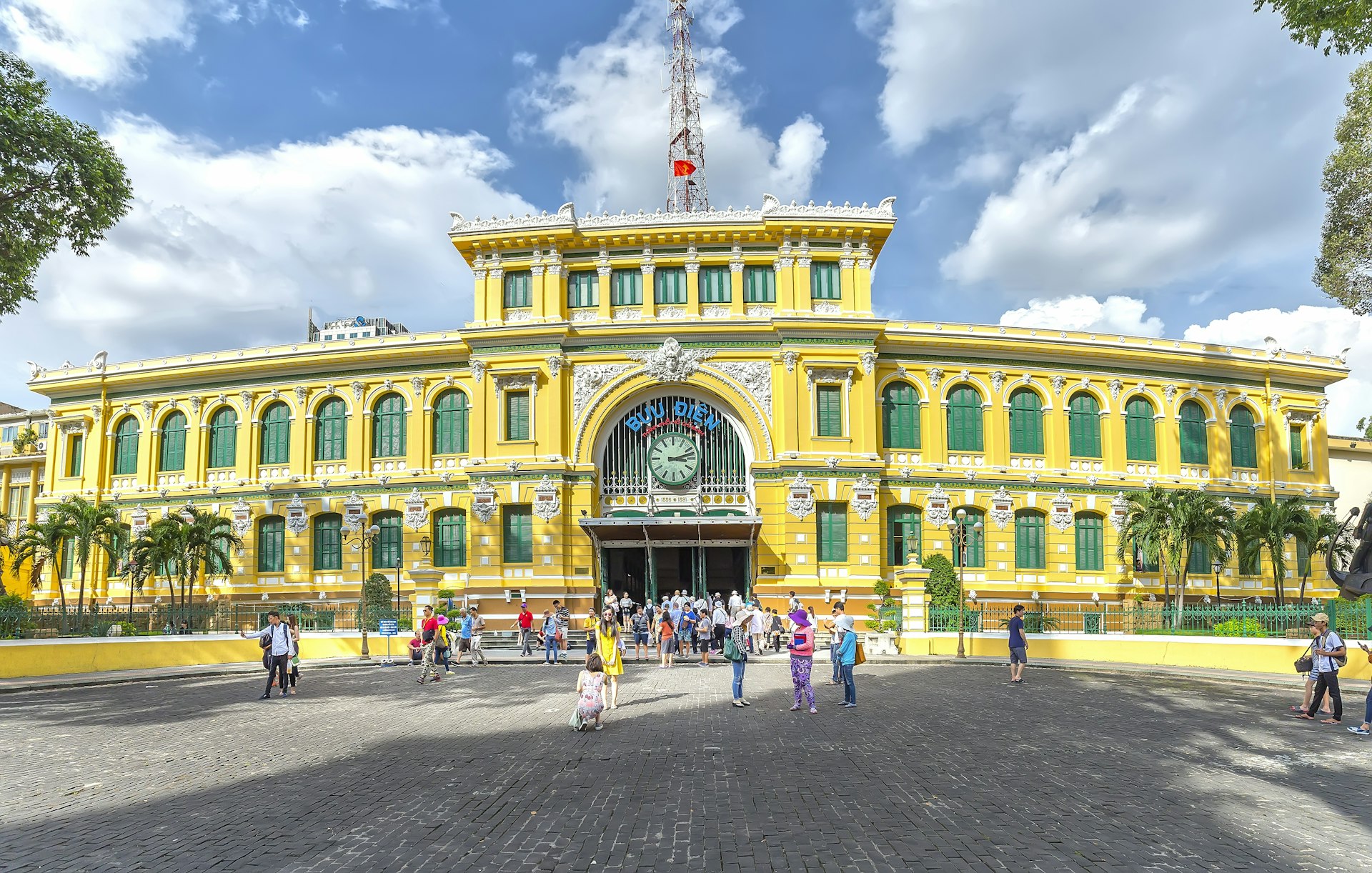 The yellow-and-green colonial French exterior of the Central Post Office in the blazing sunshine in Ho Chi Min City
