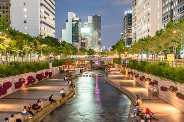 People relaxing by Cheong-Gyecheon stream in the centre of Seoul on a summer evening