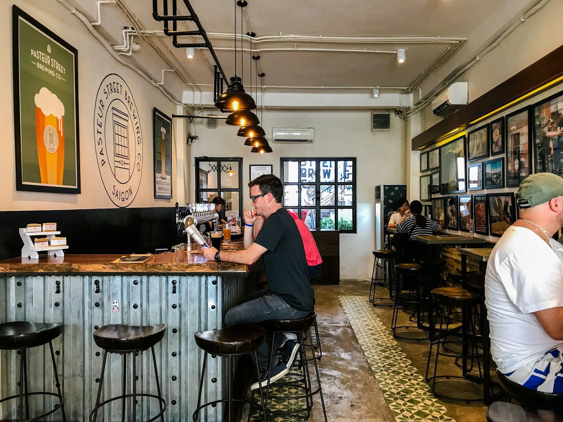 A man in glasses sits at the bar of Pasteur Street Brewing Company in Ho Chi Min City 