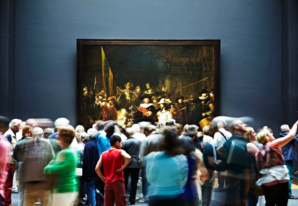 People looking at Rembrandt's Night Watch painting at Rijksmuseum