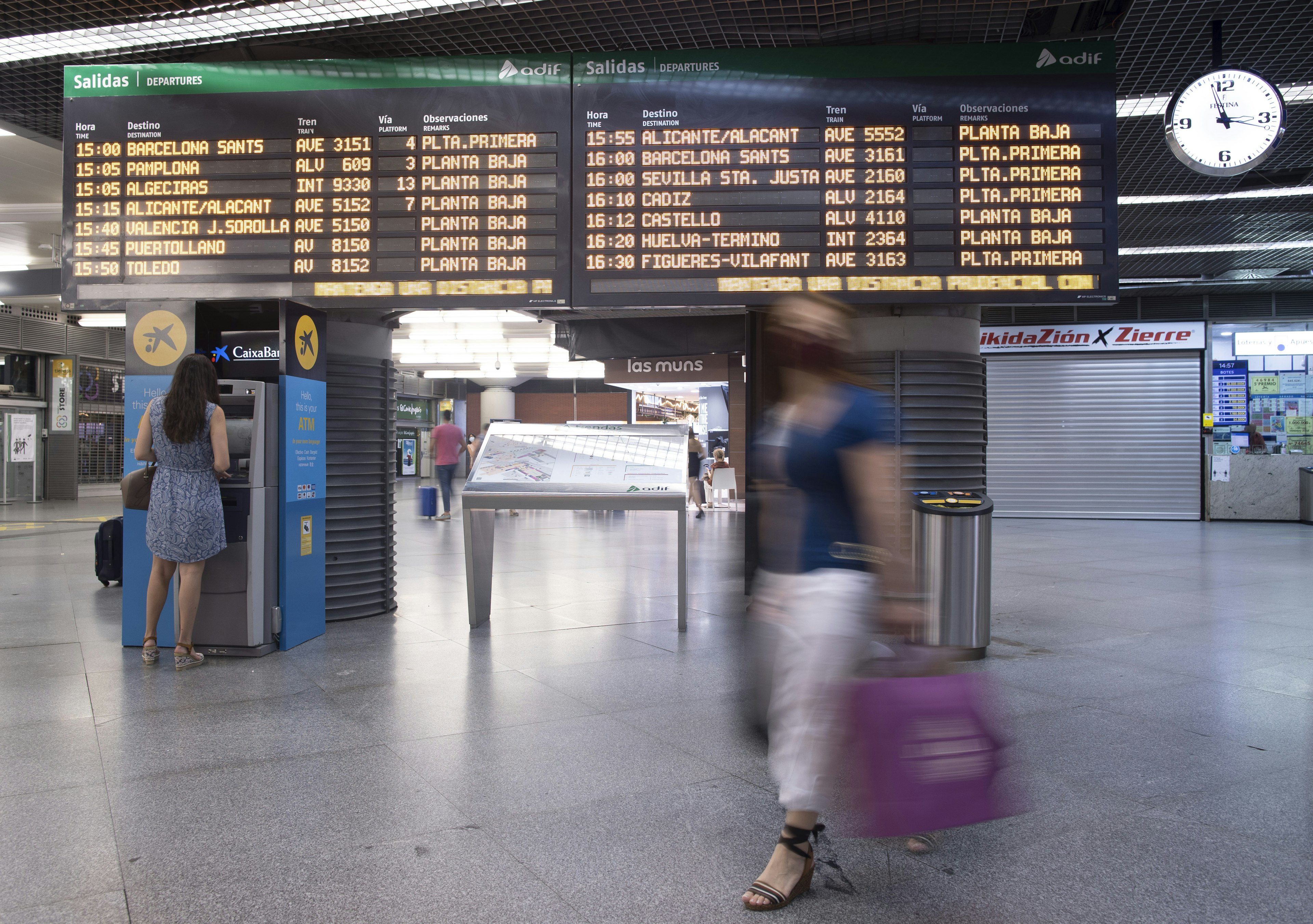 Passengers at the departures panel of the AVE station of Atocha, Madrid