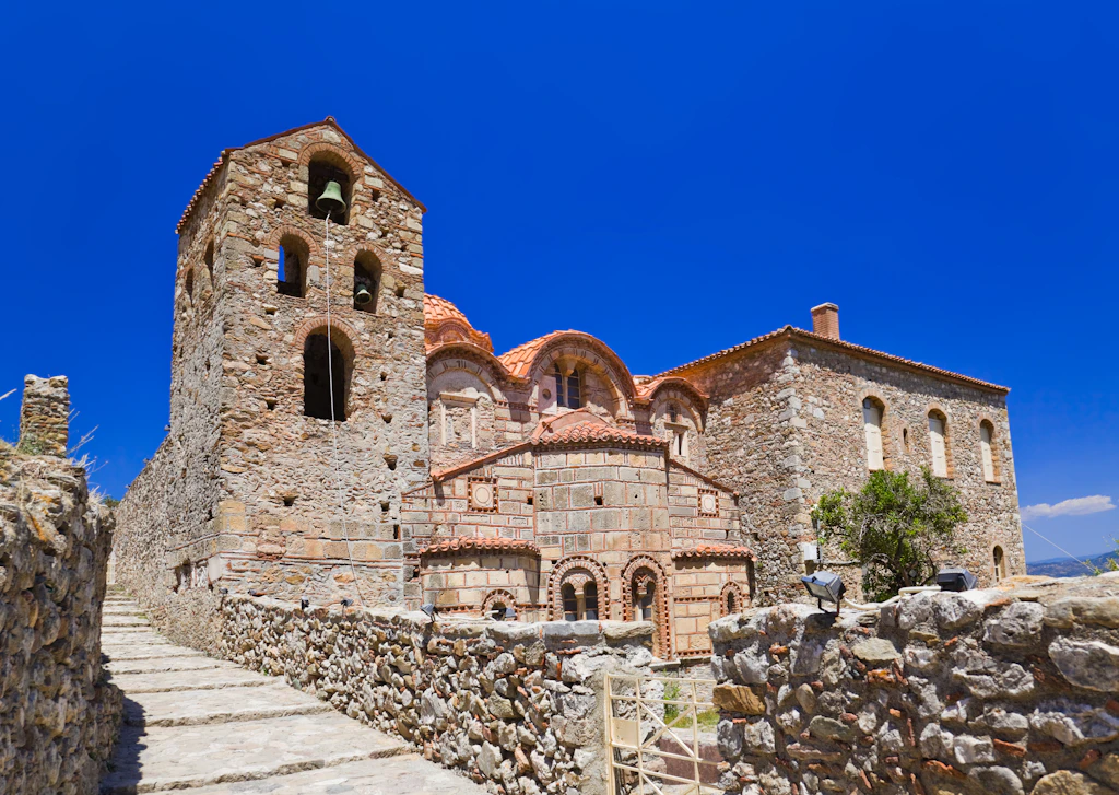 Ruins of old town in Mystras, Greece An old stone building in the ruins of Mystras, Greece. The building is a large one, with windows and doors clearly visible.