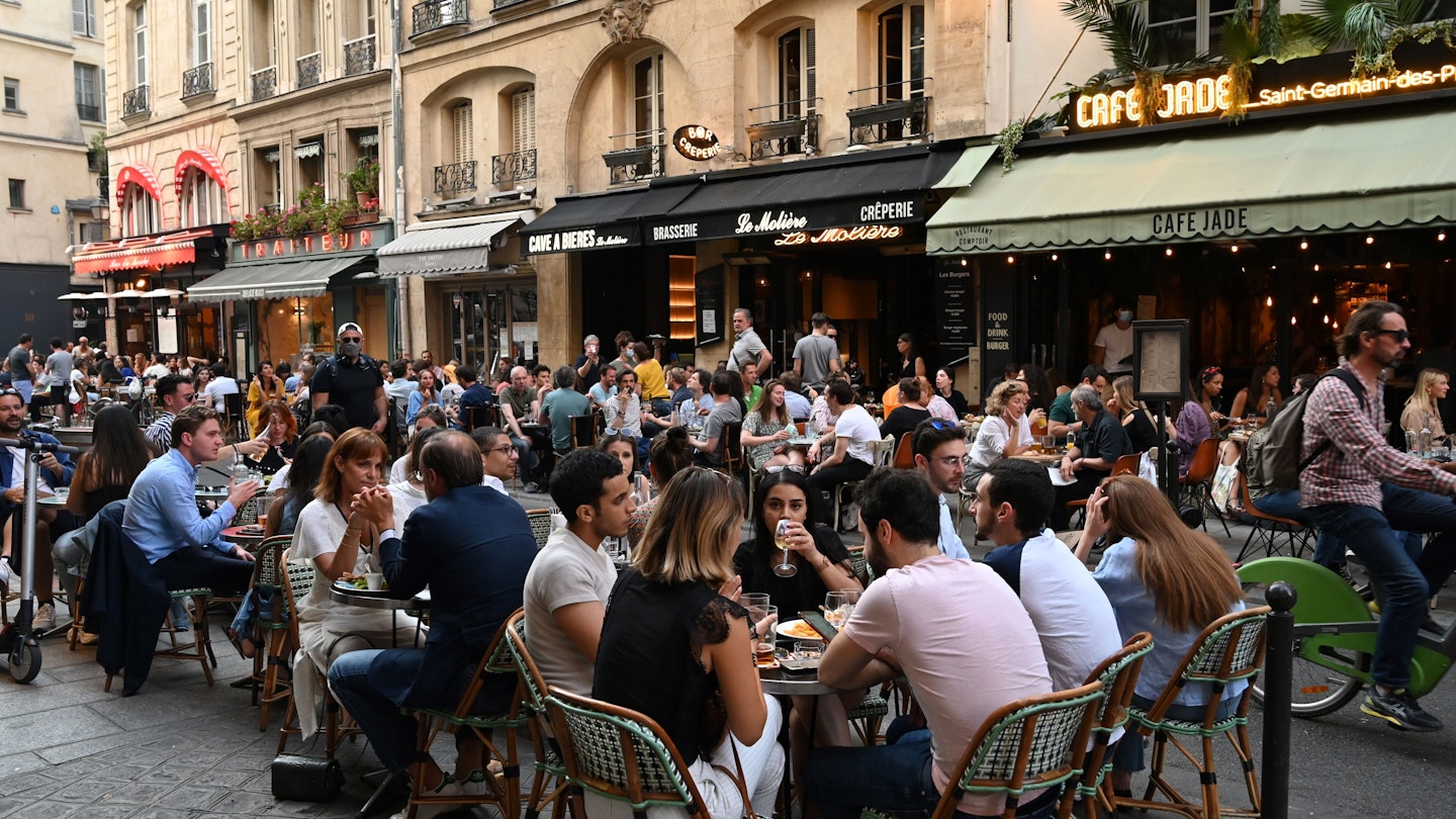 People eat and have drinks on restaurant and cafe terraces in the rue de Buci in Paris on June 2, 2020, as cafes and restaurants reopen in France with the easing of lockdown mesures taken to curb the spread of the COVID-19 pandemic, caused by the novel coronavirus. - French cafes and restaurants reopened their doors on June 2 as the country took its latest step out of coronavirus lockdown, with clients seizing the chance to bask on sunny terraces after 10 weeks of closures to fight the outbreak. (Photo by BERTRAND GUAY / AFP) (Photo by BERTRAND GUAY/AFP via Getty Images)