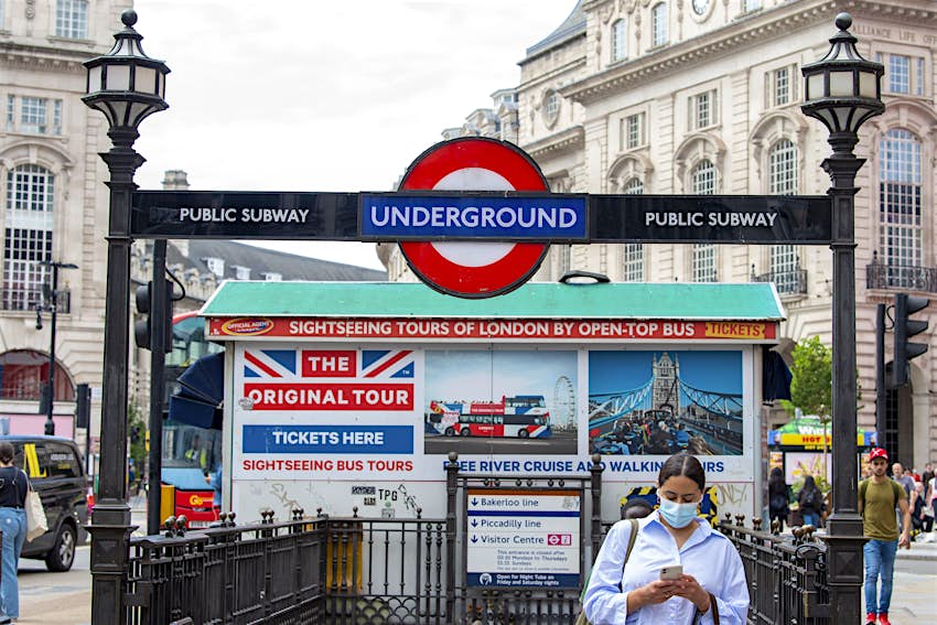 伦敦，英国 -  2021/07/13：一只妇女留下皮卡迪利马戏团地铁站，穿着面罩。在英国公共交通工具上的强制性穿着面部面具是在博士约翰逊确认这一天的7月19日杜布斯的自由日结束最强大的Covid-19限制将结束。（照片由戴维什兰/ SOPA图像/ Lightrocket通过Getty Images