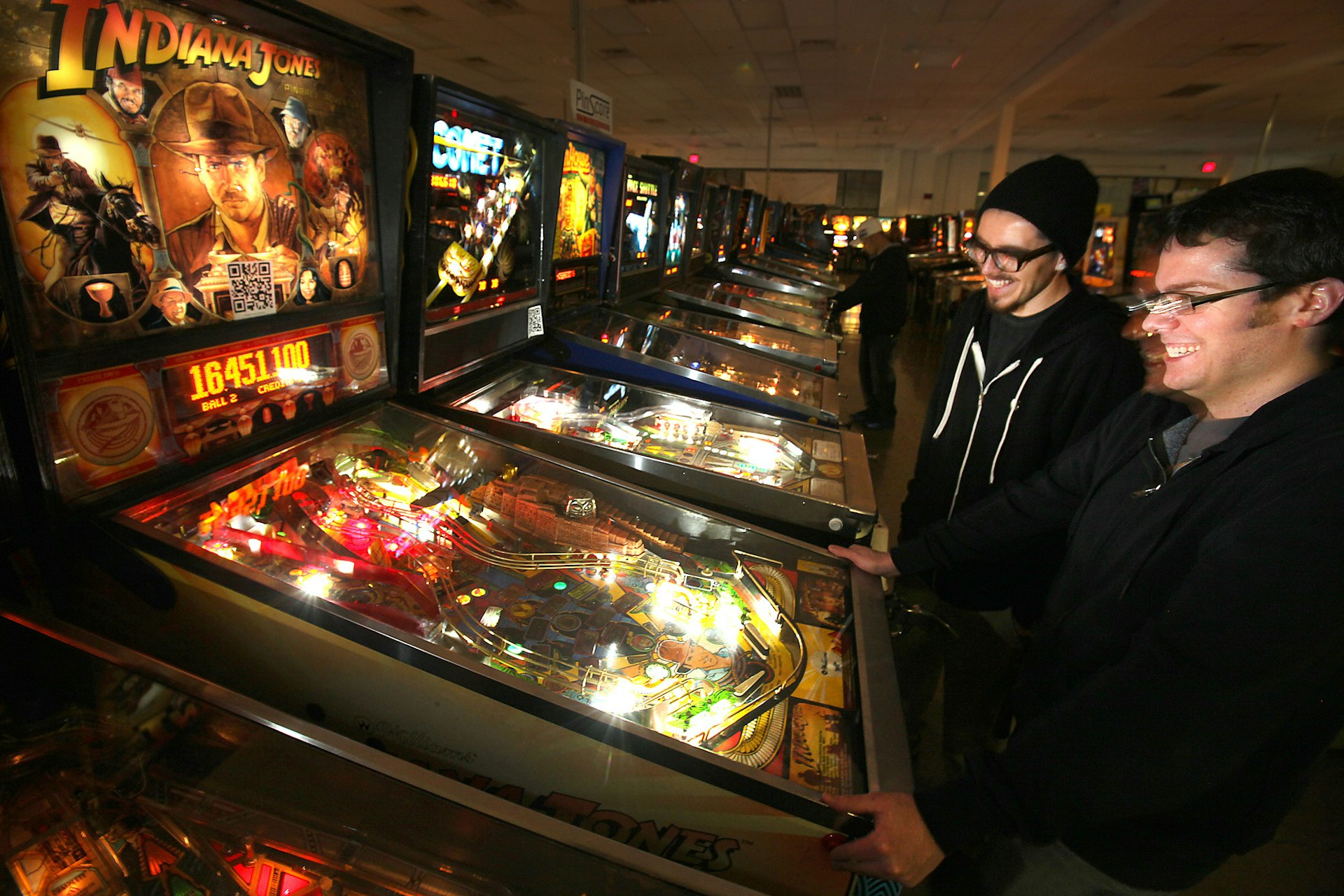 Two male friends play pinball in the Pinball Hall of Fame in Las Vegas