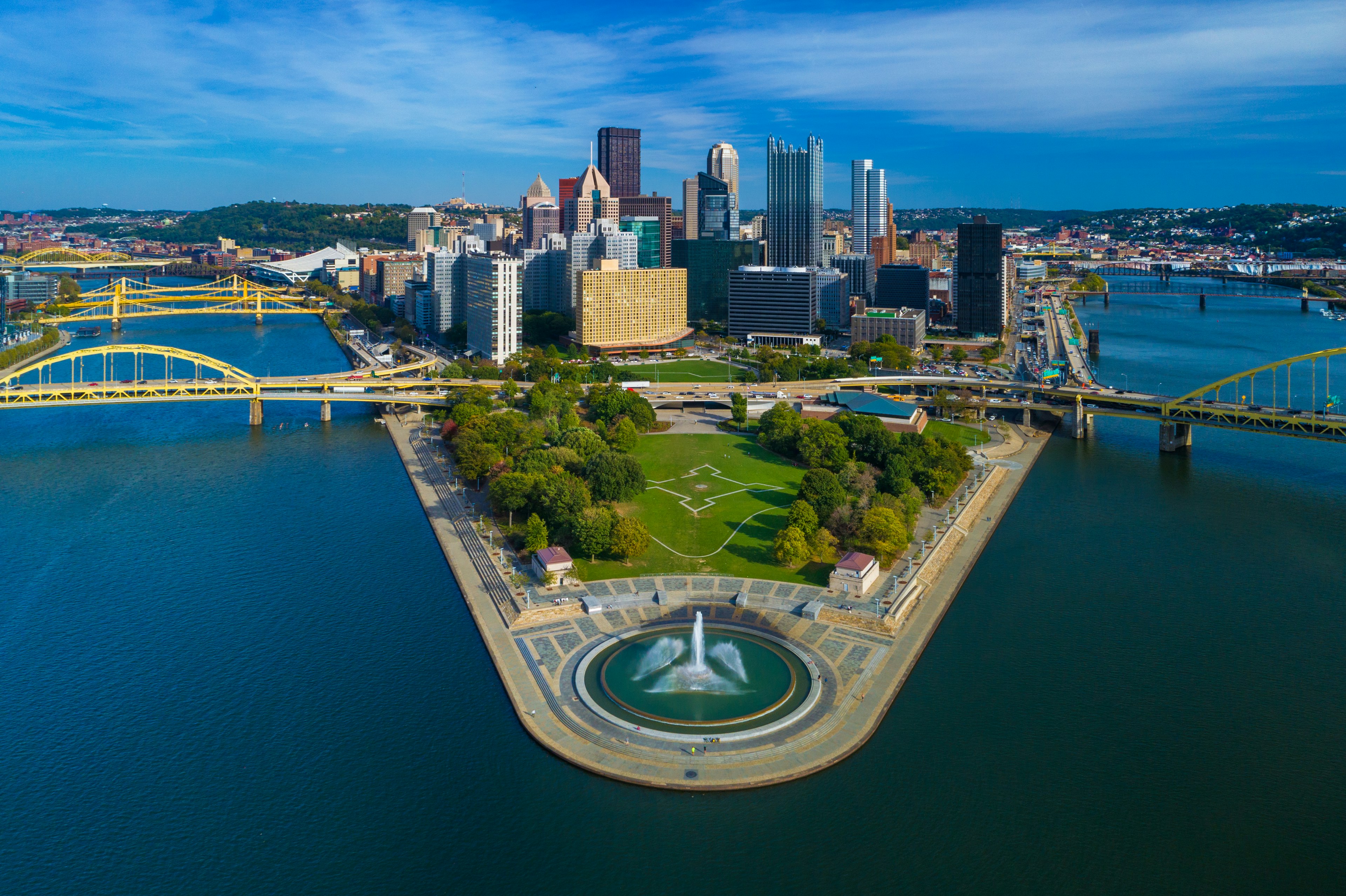 Downtown Pittsburgh skyline aerial view with Fort Duquesne (including a fountain), Point State Park, I-279, Allegheny River (left), Fort Duquesne Bridge (left), Monongahela River (right) and Fort Pitt Bridge (right) in the foreground.