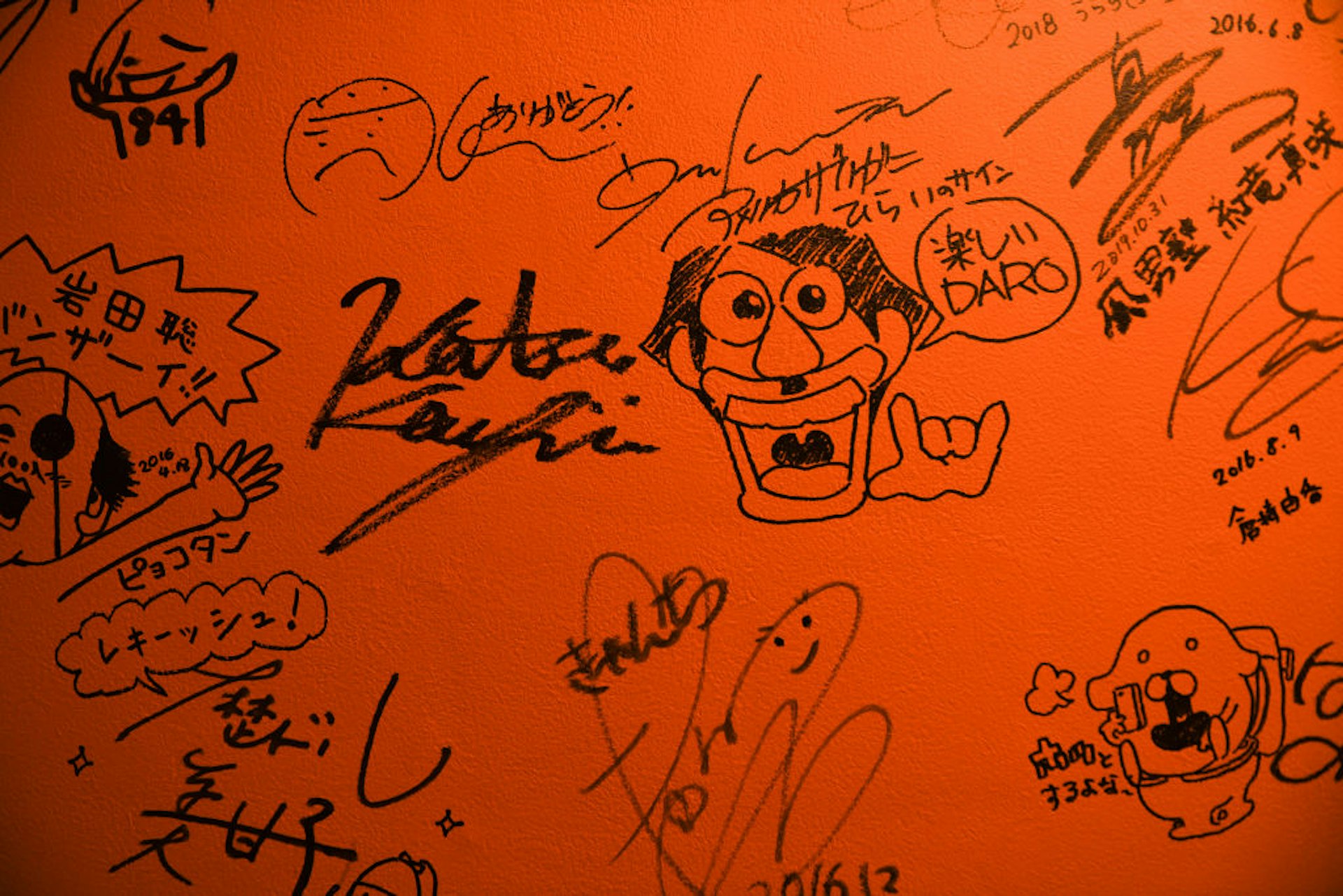 Autographs signed on a bathroom wall inside 84