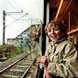 A very excited young boy looks out of a train window.