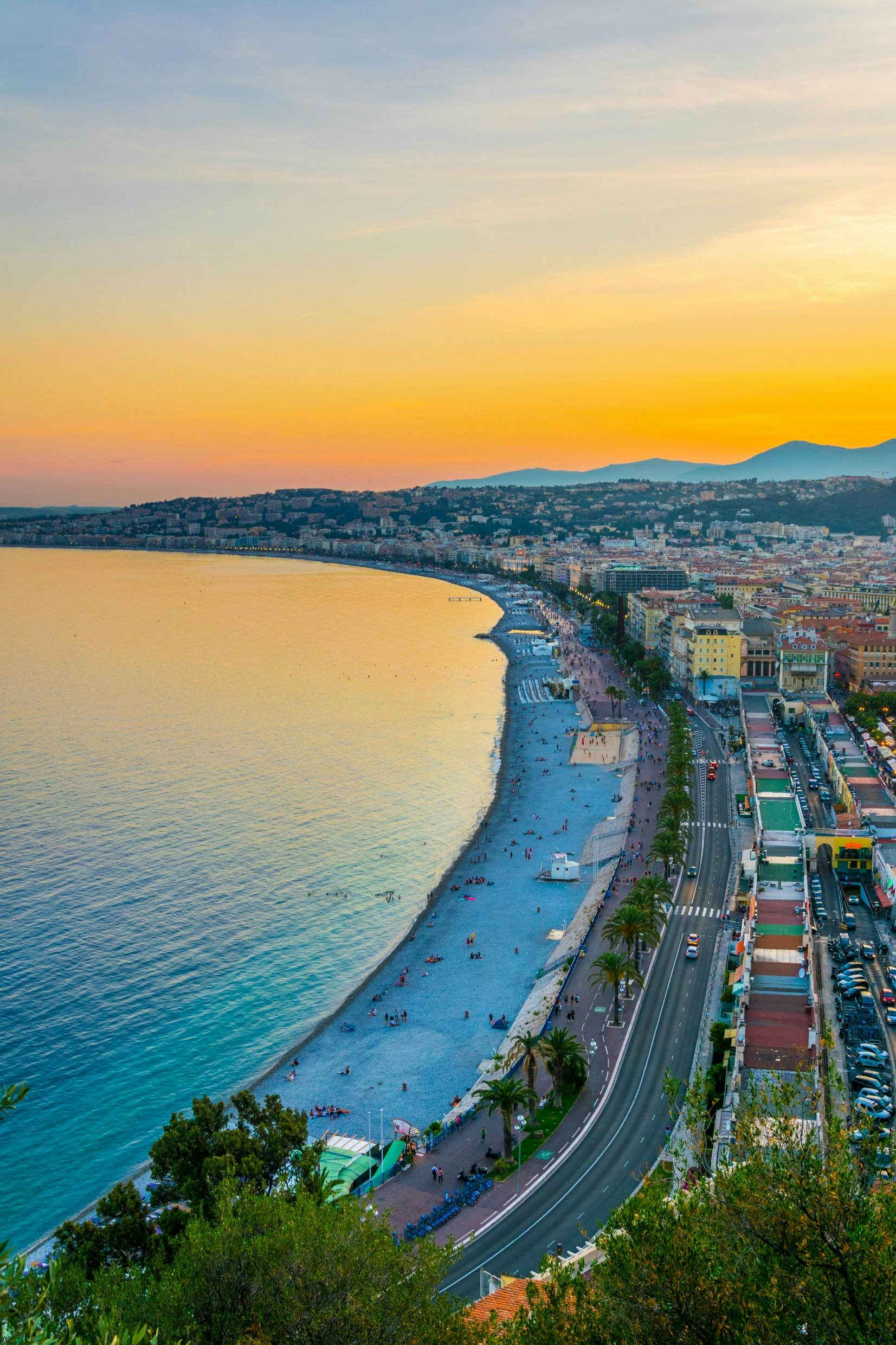 Golden sunset over the cityscape and beach of Nice, France taken in portrait orientation.