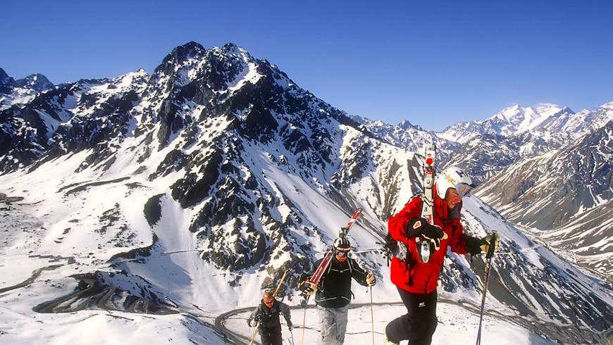 Un grupo de esquiadores escala nieve fresca con esquís sobre sus hombros en el interior de Portillo, un popular centro de deportes de invierno en la Cordillera de Los Andes, Chile