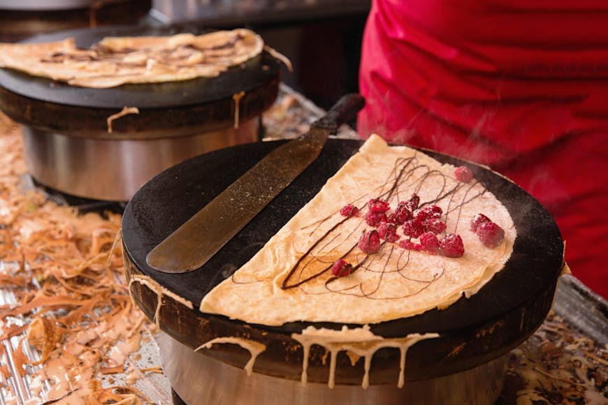 En crepe med hallon som tillagas på en kokplatta av en gatuförsäljare i Paris, Frankrike.