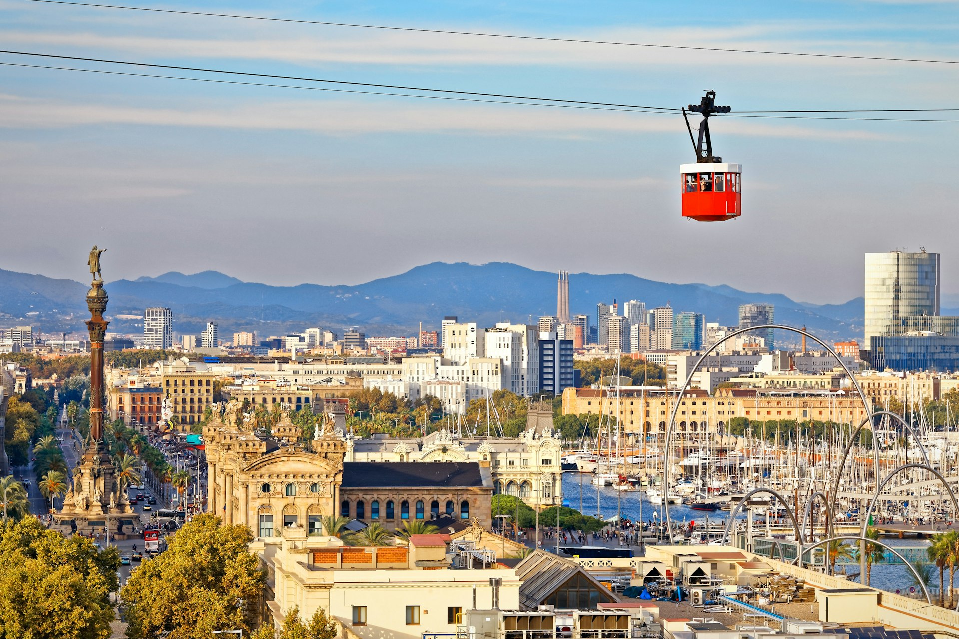 Red cabin of funicular (cable car) stands out on Barcelona's city backdrop
