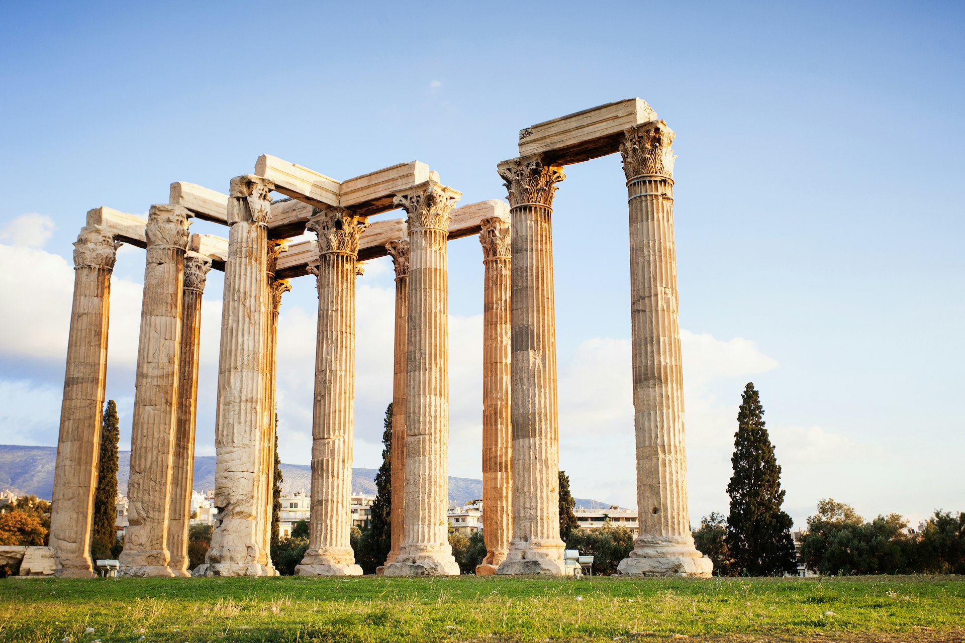 Tall stone columns of the Temple of Olympian Zeus in Athens stand in the sunshine