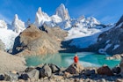 Woman sitting on a rock and admiring Mount Fitz Roy.