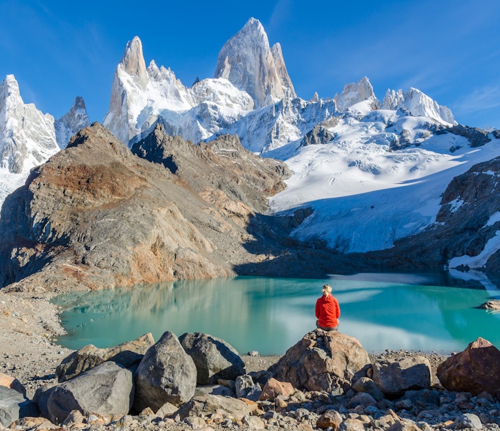 Woman sitting on a rock and admiring Mount Fitz Roy.