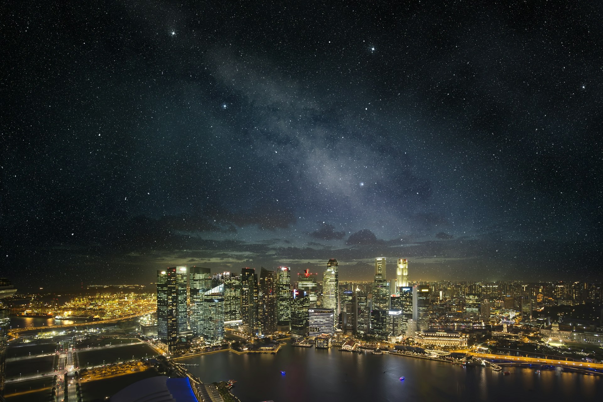 Singapore skyline at night, under a starry night sky.
