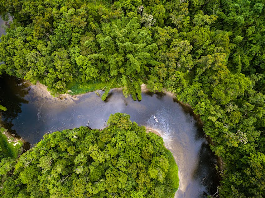 Uma vista aérea de um caiaque em uma curva no Rio Amazonas na floresta amazônica, Brasil.