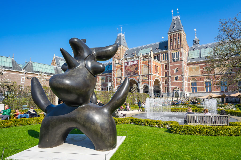 A Henry Moore statue sits amongst the plants and shrubs of the Rijksmuseum sculpture garden