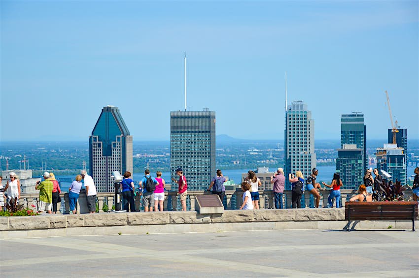 Kondiaronk Belvedere, Parc du Mont-Royal A row of people stand at a viewpoint looking towards a city skyline