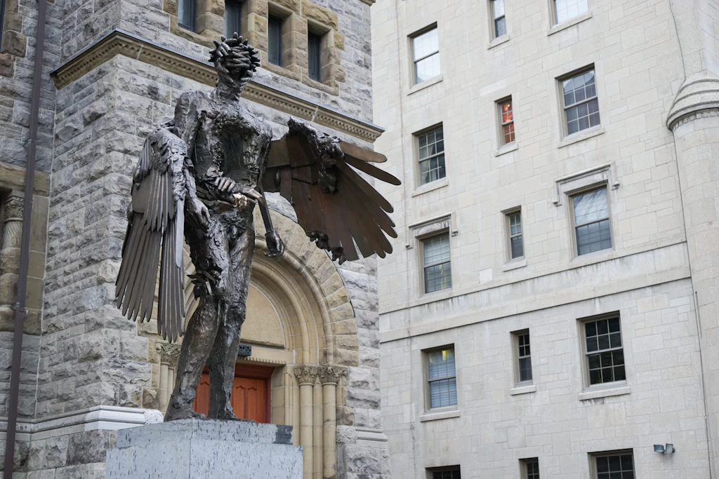 'The Eye' sculpture, Montreal Museum of Fine Arts A large metallic sculpture of a human form with wings stands on a plinth outside a building