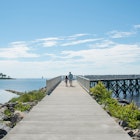 A view down the pier boardwalk on a beautiful summer day by the Long Island Sound at Calf Pasture Beach in Norwalk, Connecticut USA; Shutterstock ID 1768878476; your: Tasmin Waby; gl: 65050; netsuite: Online editorial; full: Demand project