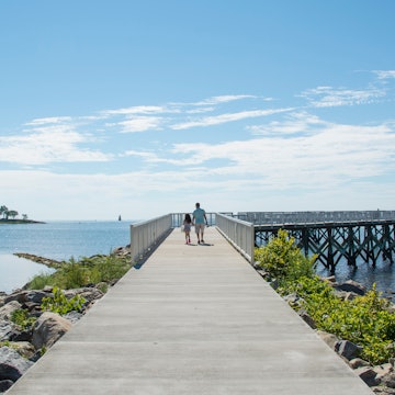 A view down the pier boardwalk on a beautiful summer day by the Long Island Sound at Calf Pasture Beach in Norwalk, Connecticut USA; Shutterstock ID 1768878476; your: Tasmin Waby; gl: 65050; netsuite: Online editorial; full: Demand project