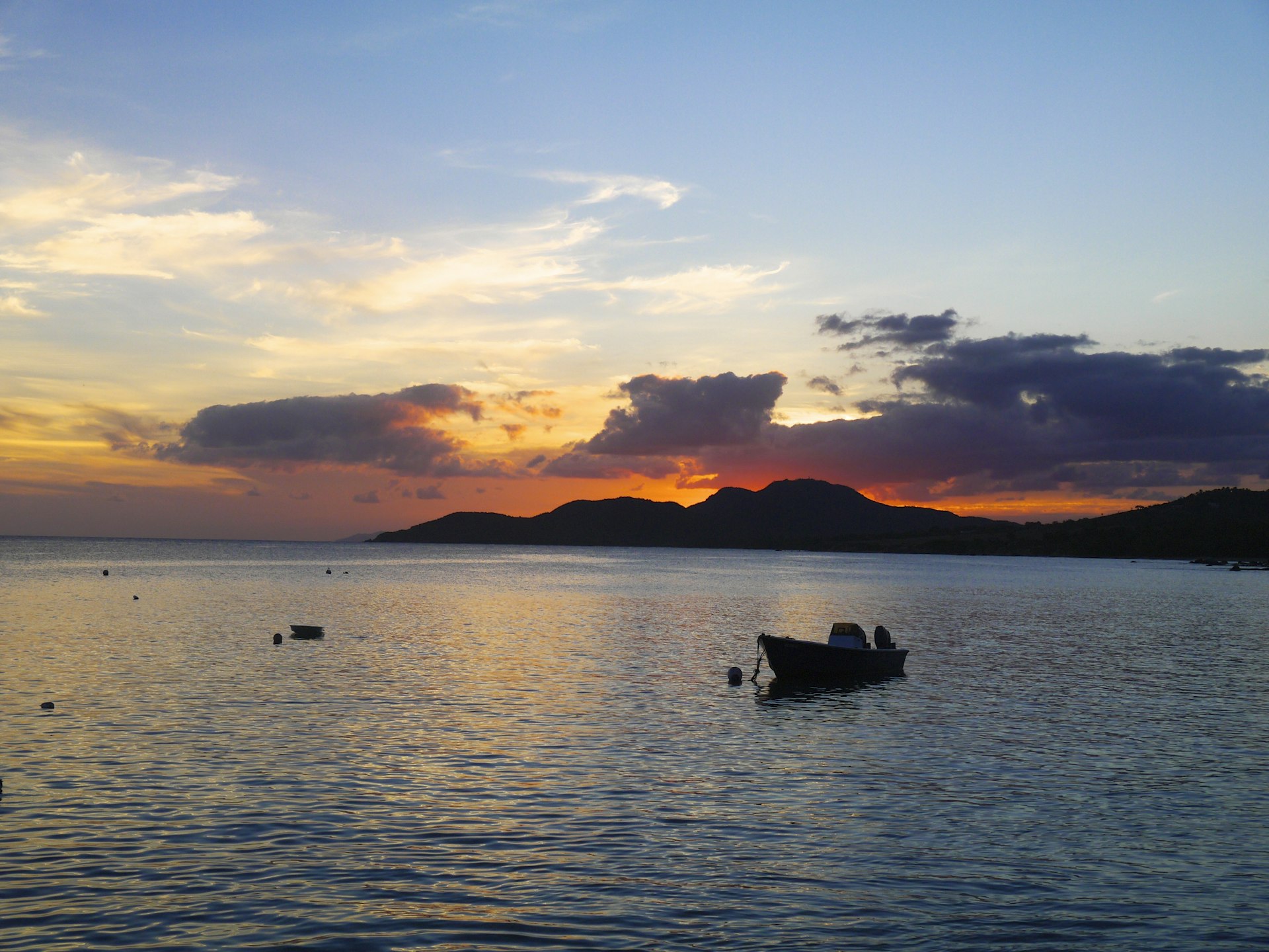 A small boat is moored on the waters in Vieques at sundown 