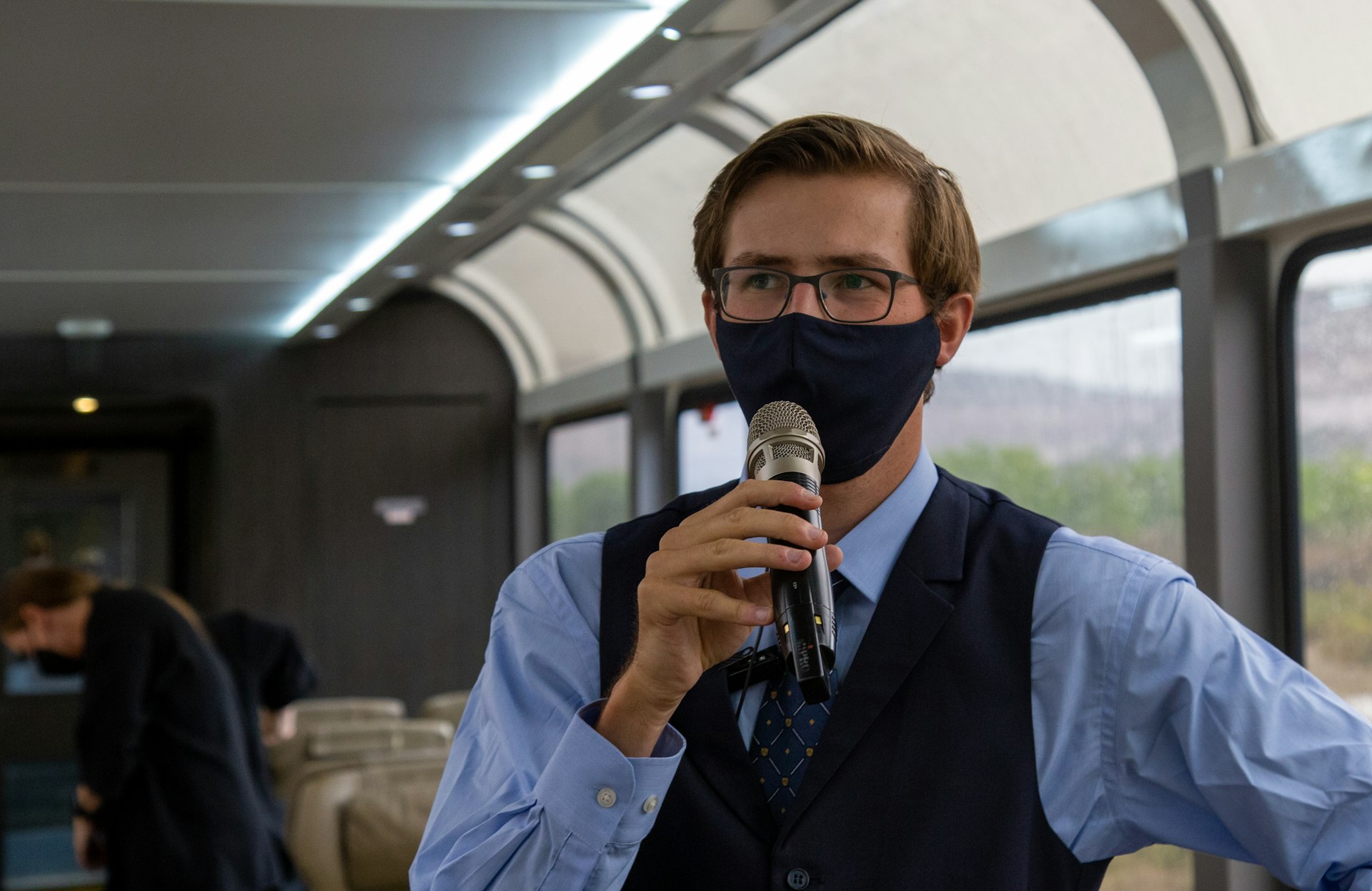 A man in a facemask holding a microphone