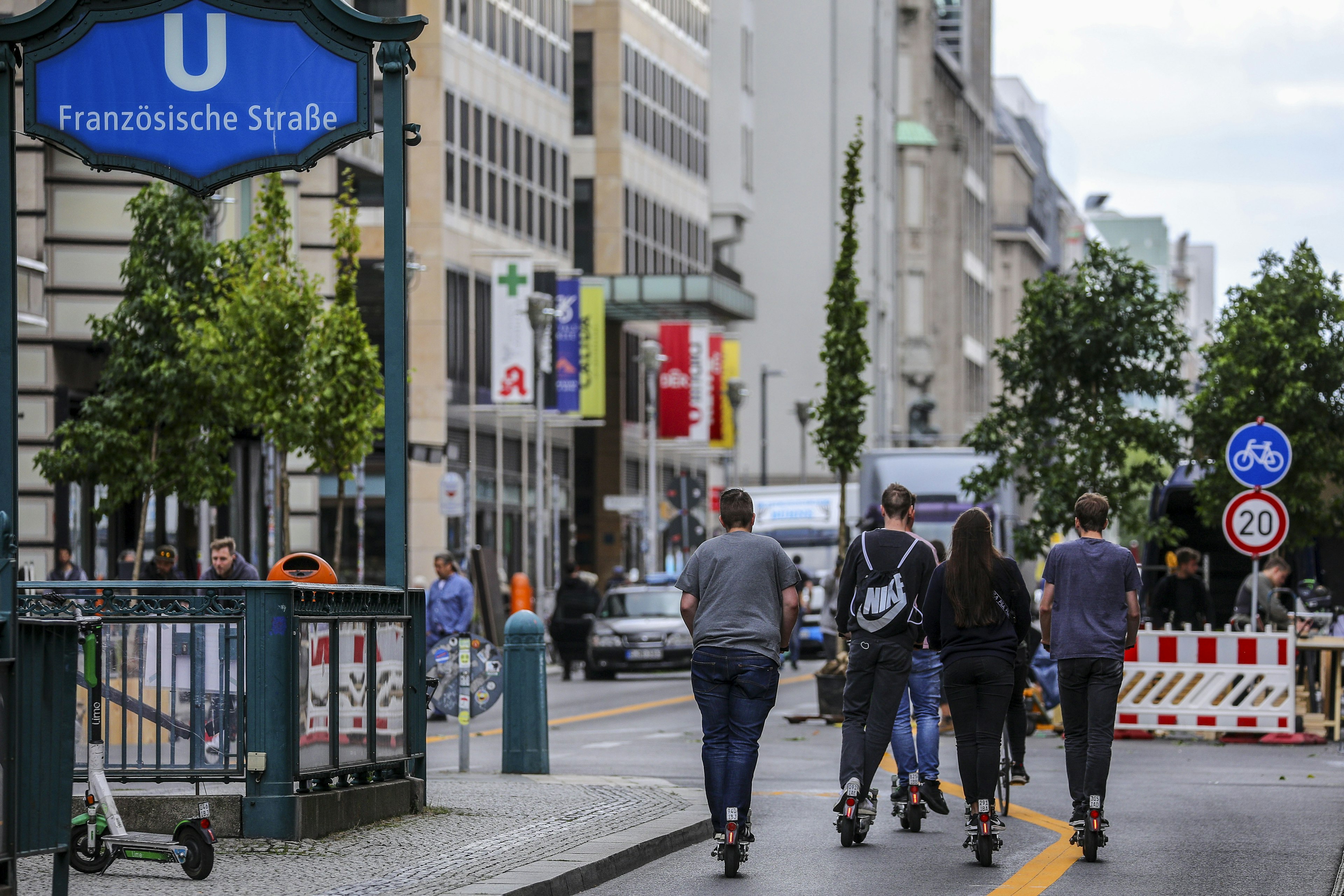 People on E-scooters ride along Friedrichstrasse in Berlin