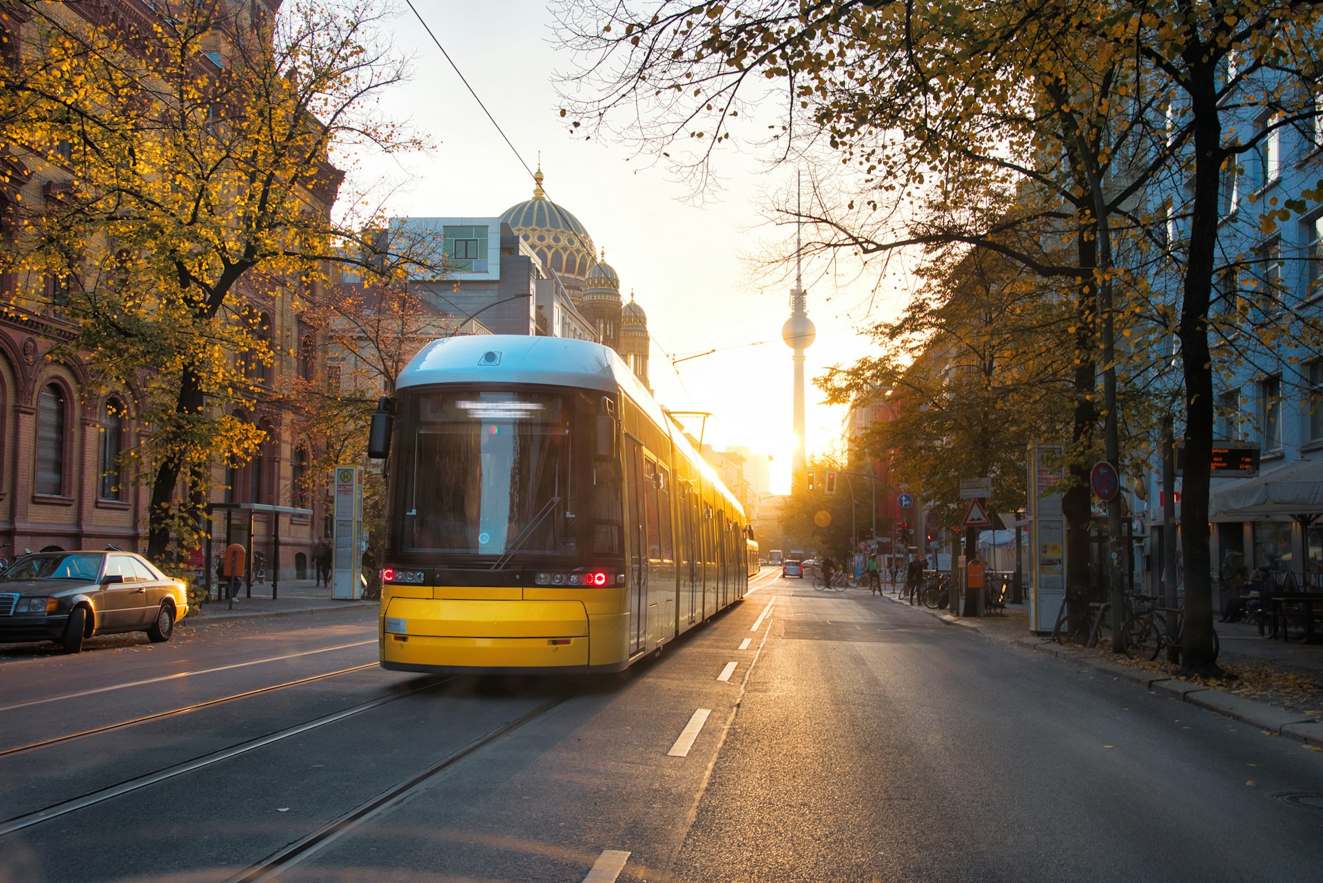 A yellow tram in the early morning sunlight along Berlin's Oranienburger Strasse