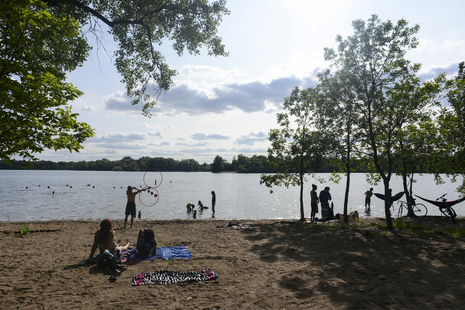 People enjoying the beach and the water at Cedar Lake East Beach in Minneapolis, Minnesota