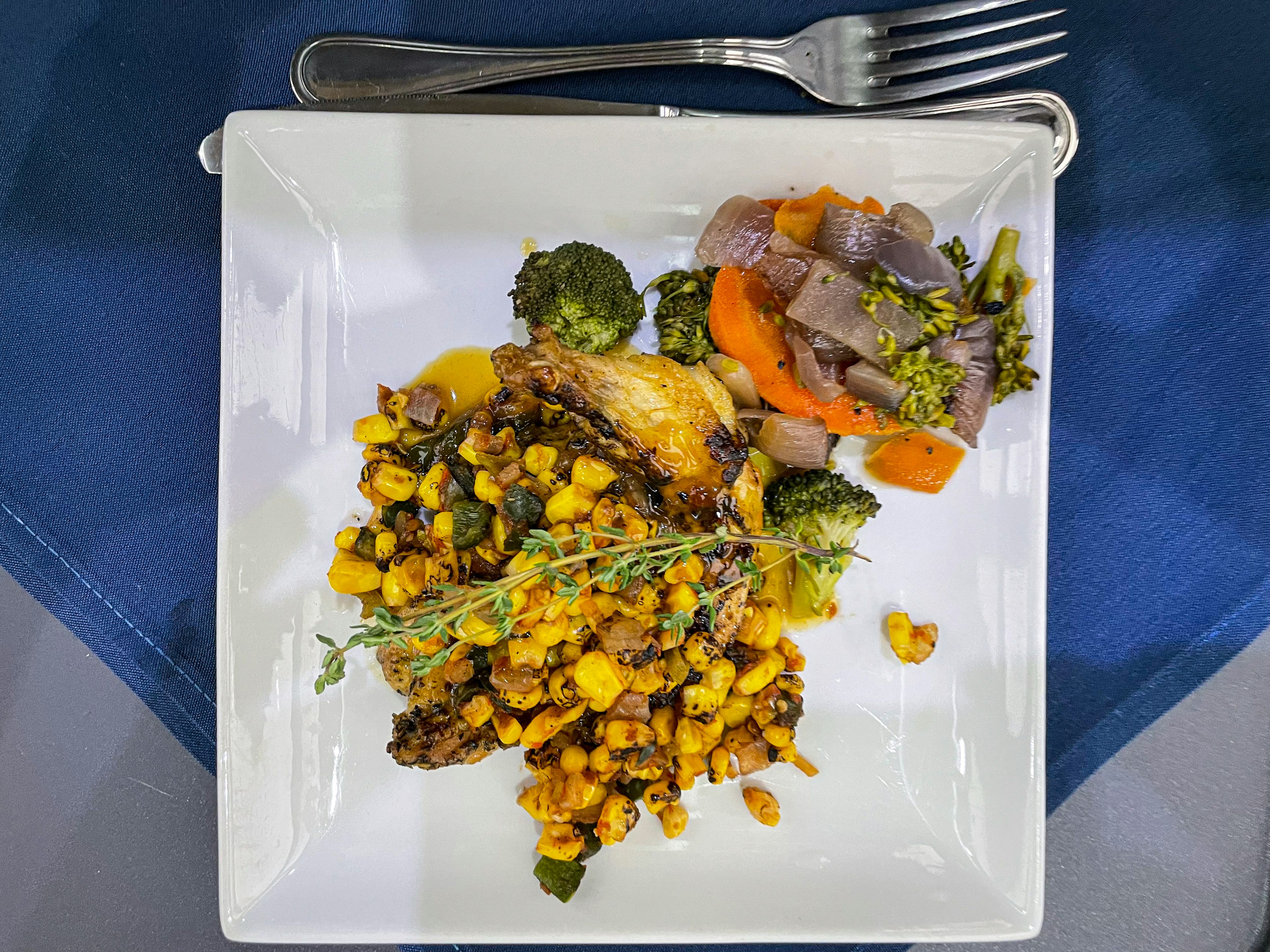 A plate of roasted chicken with corn and poblano salsa