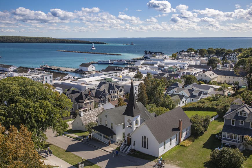 An aerial view of the main town on Mackinac Island, Michigan, with the blue waters of Lake Huron visible in the background