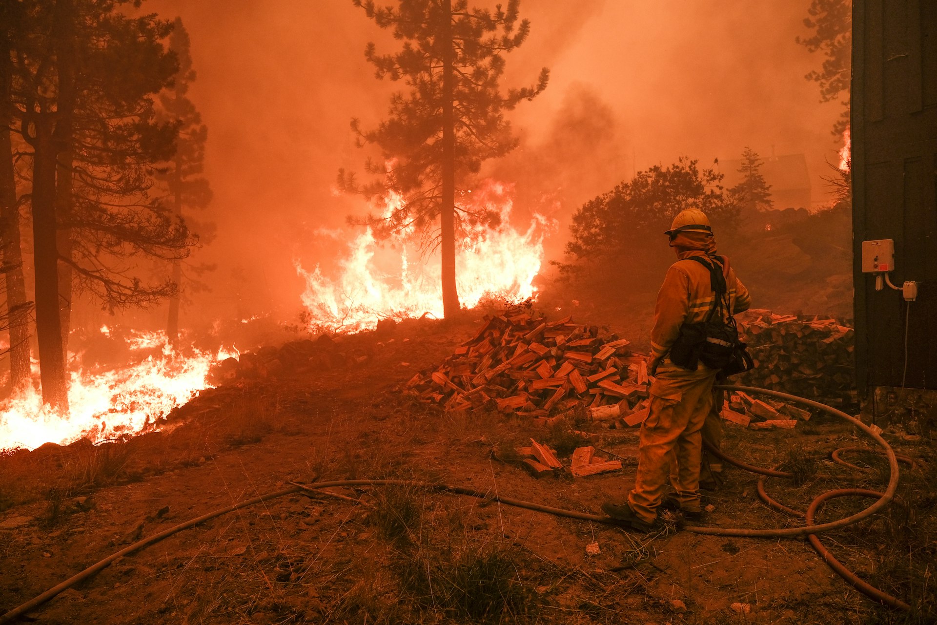 A firefighter monitors a fire threatening the Echo Summit Lodge during the Caldor Fire near Echo Lake, California