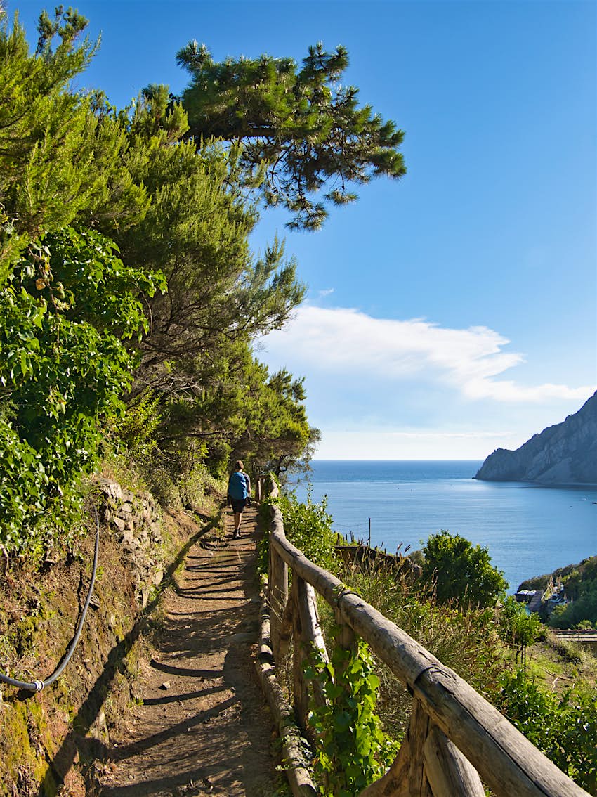 A hiker enjoys the beautiful walk on the Sentiero Azzurro (Blue Trail) hiking trail in Cinque Terre, Italy