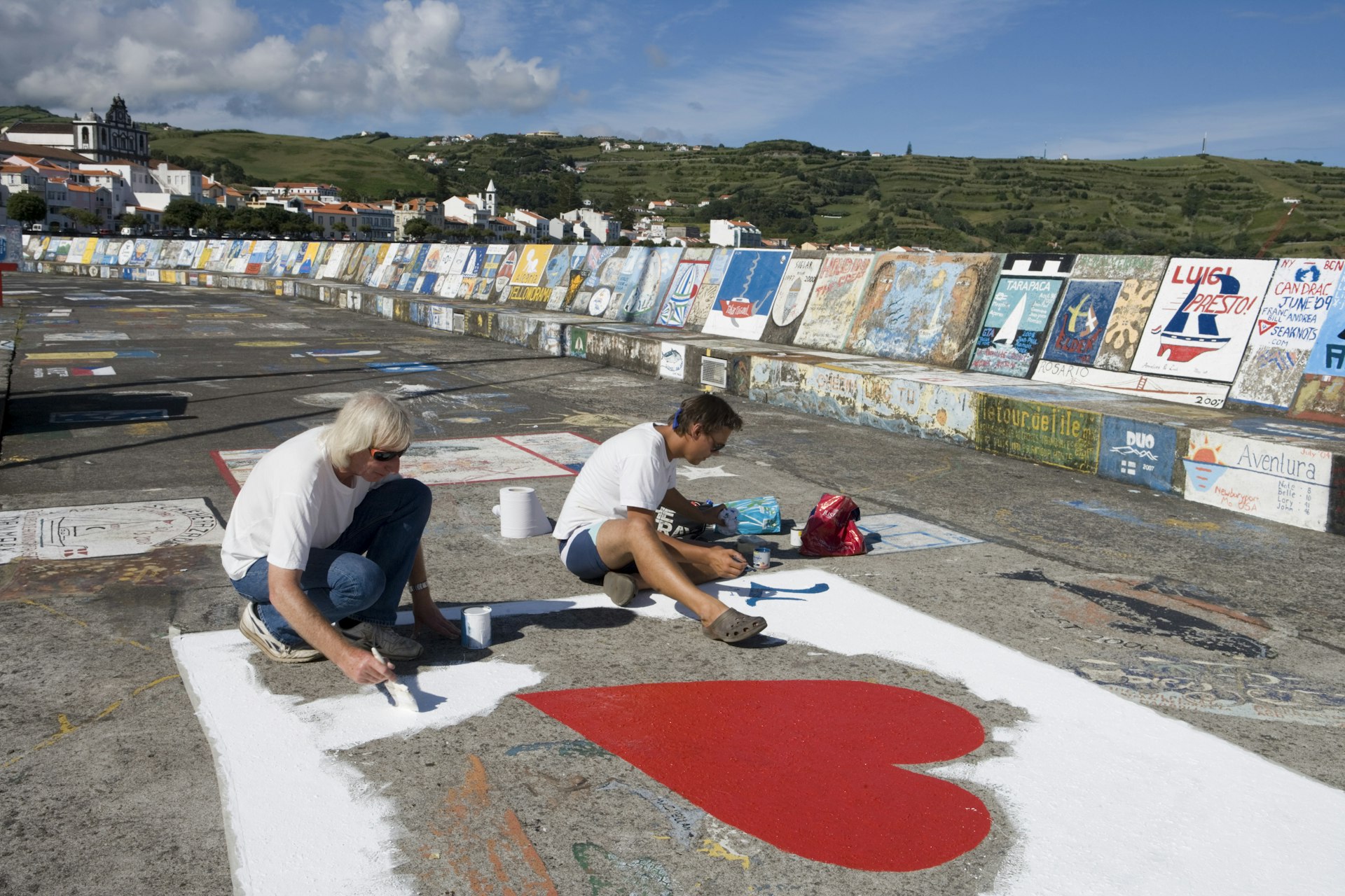 Sailors painting mural on the jetty at Horta, the Azores