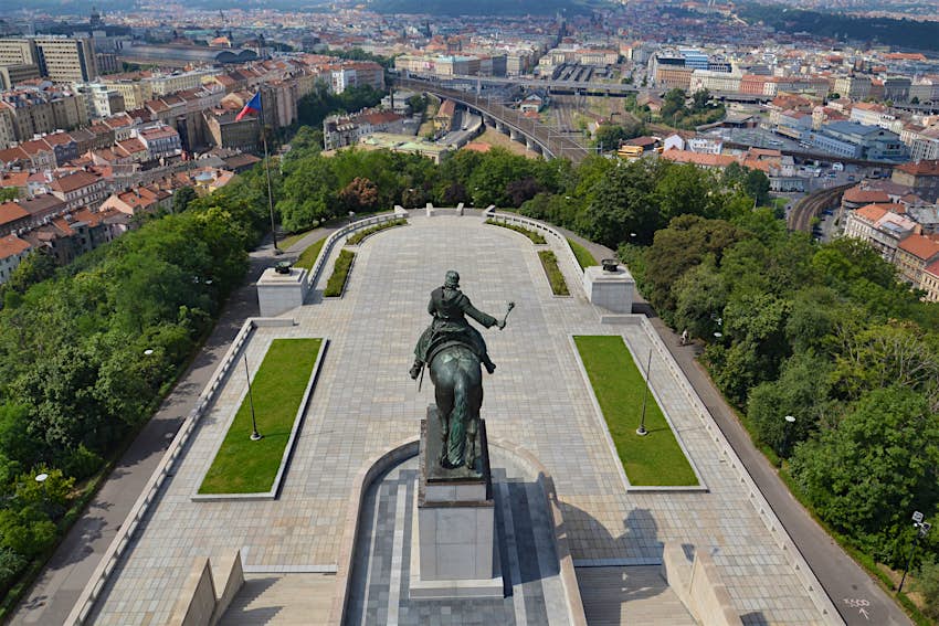 Prague panorama An aerial view of a large statue of a man on horseback, standing on the top of a hill in Prague. Around the hill, the cityscape is visible.