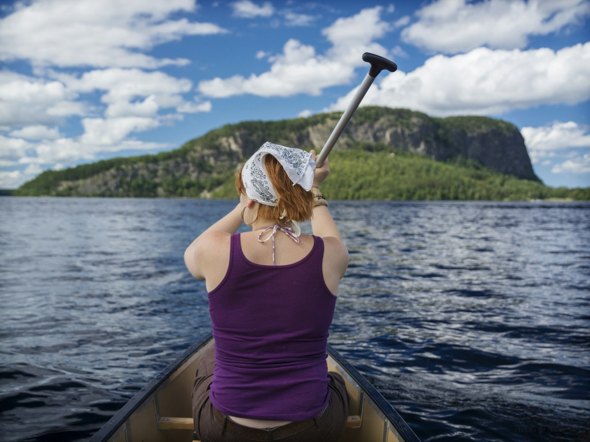 Woman paddling a canoe on Moosehead Lake in Maine on a sunny day