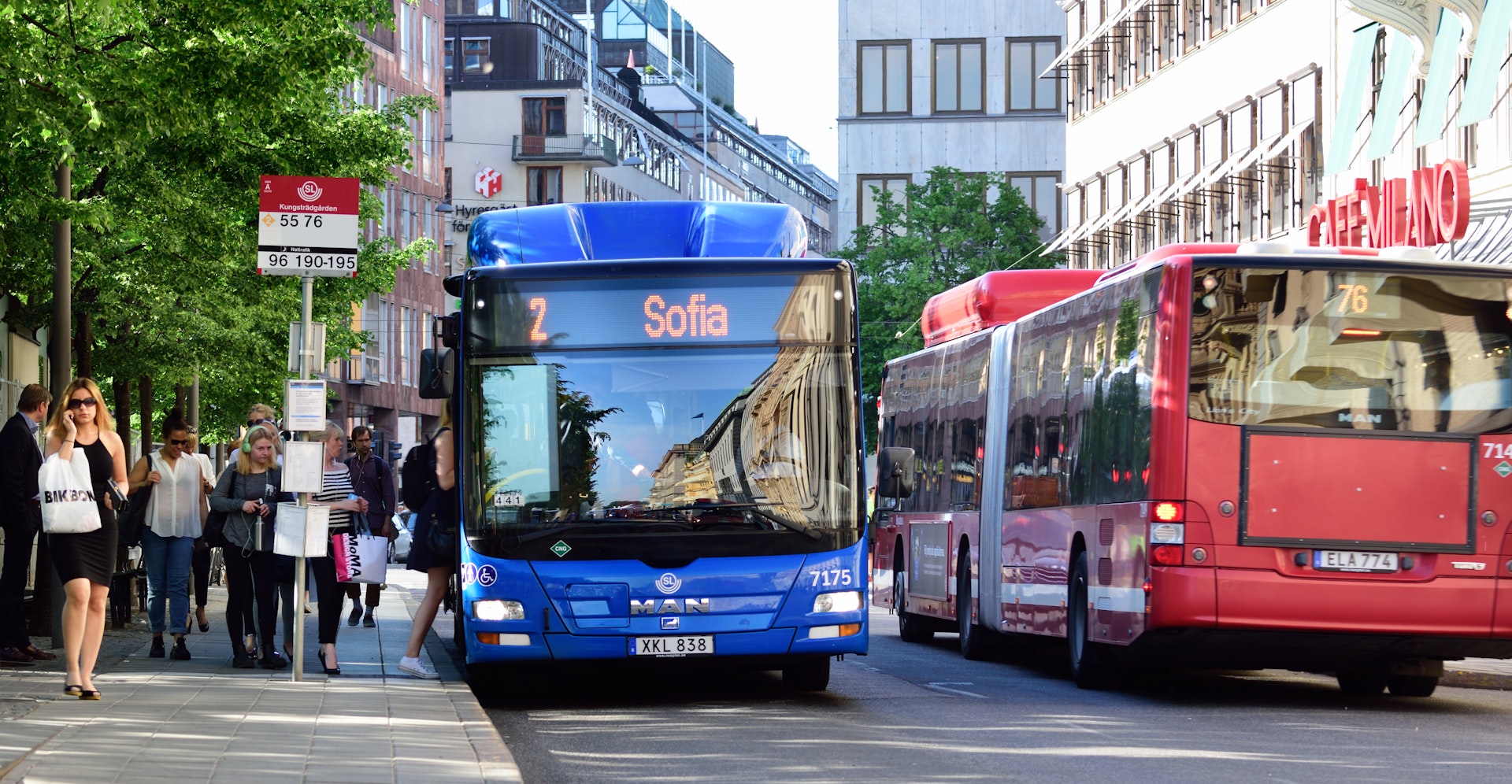 People entering bus at bus stop in Stockholm